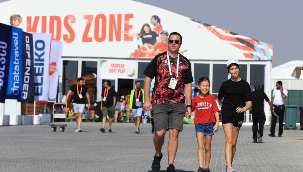 Families enjoying the kids’ zone activities at Dubai 7s 2024 with carnival rides and games.