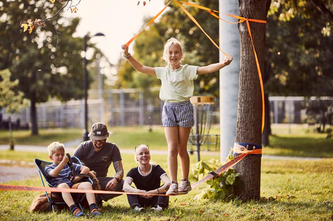 Kids enjoying slacklining in the UAE - Fun outdoor activity for improving balance and coordination.