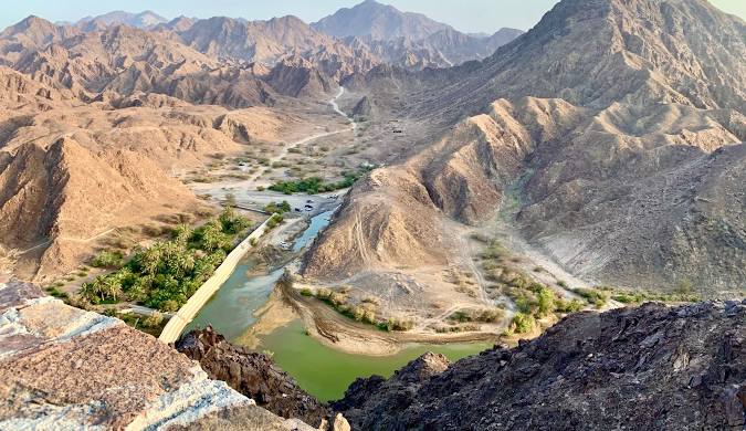 Adventurers trekking the Wadi Shawka Trail in Ras Al Khaimah, known for its rugged terrain, freshwater pools, and scenic beauty.