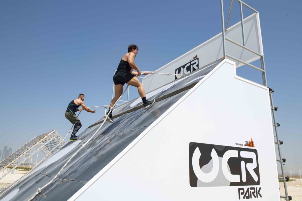 Participants competing in Dubai Games 2025 obstacle course challenges, showcasing teamwork and endurance in UAE.