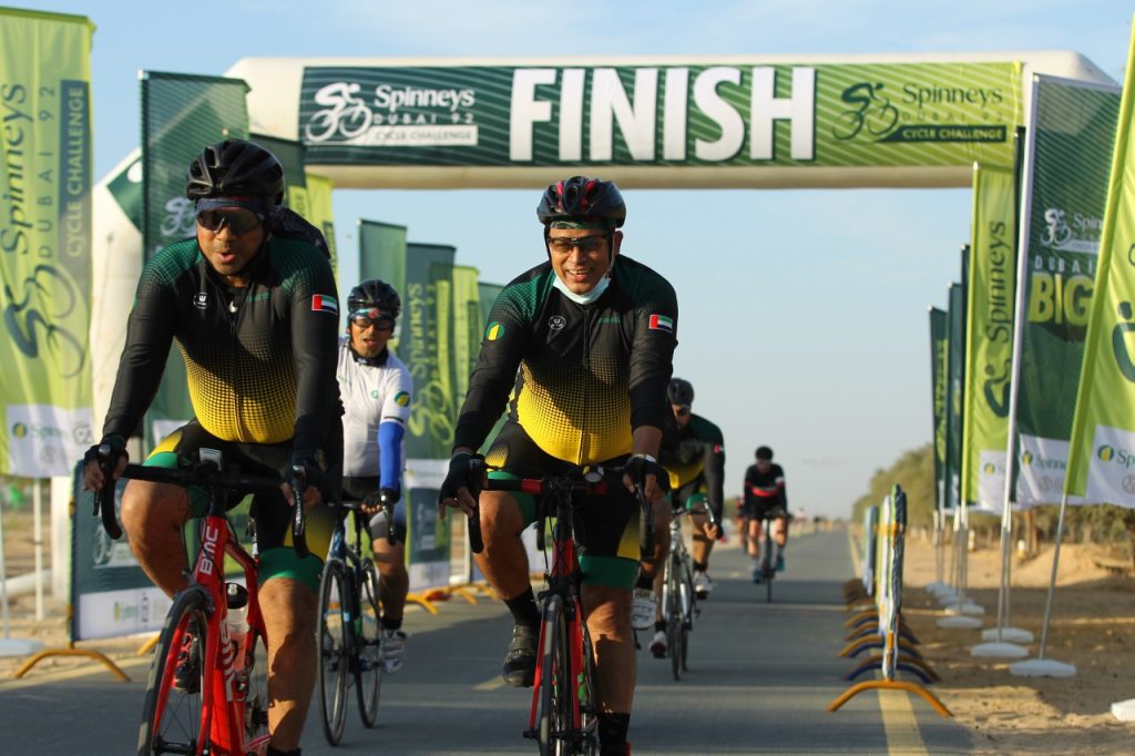 Cyclists finishing Build-Up Ride 4 and celebrating at Al Qudra Cycle Track in Dubai.