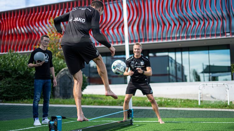 German football team performing slackline drills to improve core strength.