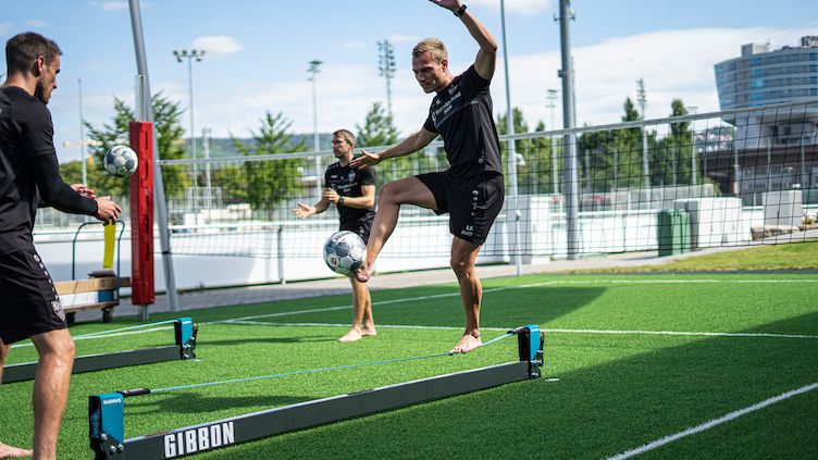 German football player enhancing balance on a slackline during training.
