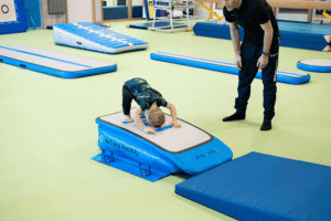 a child backflip on a mat