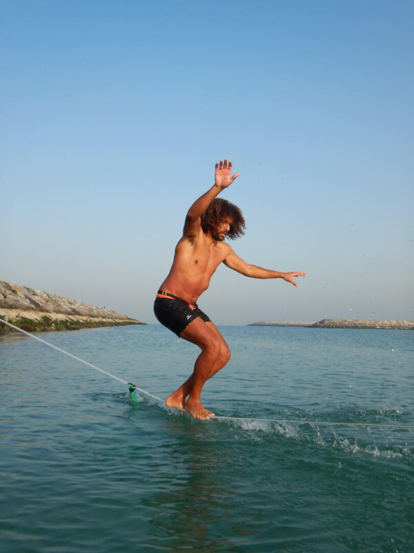 a man on a slackline in the water